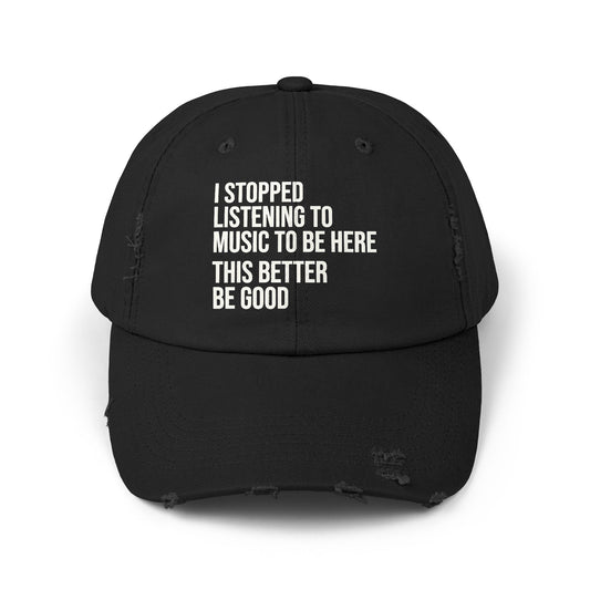 A black distressed baseball cap with white text on the front that reads 'I STOPPED LISTENING TO MUSIC TO BE HERE THIS BETTER BE GOOD'.