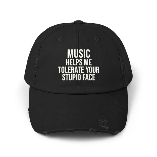 A black distressed baseball cap with white text on the front that reads 'MUSIC HELPS ME TOLERATE YOUR STUPID FACE'.