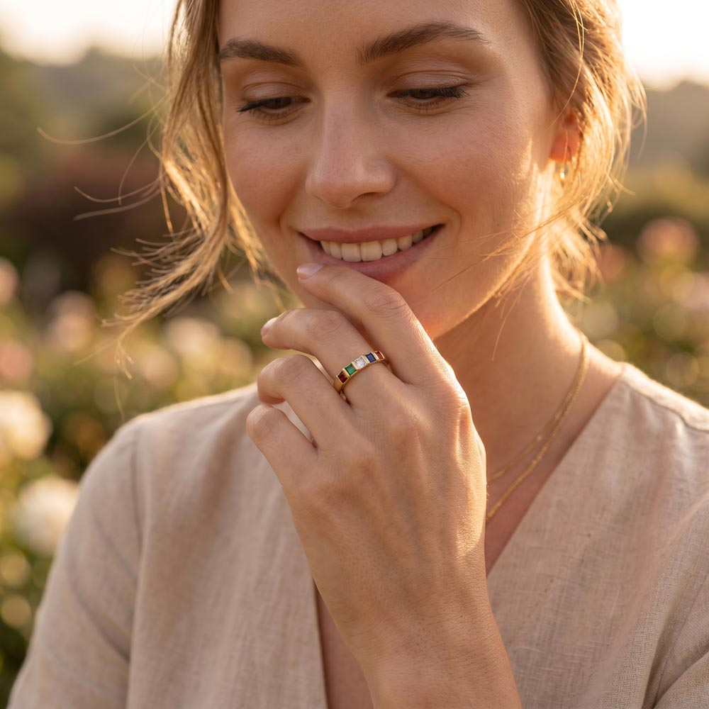 Woman wearing gold stackable birthstone ring with colorful stones