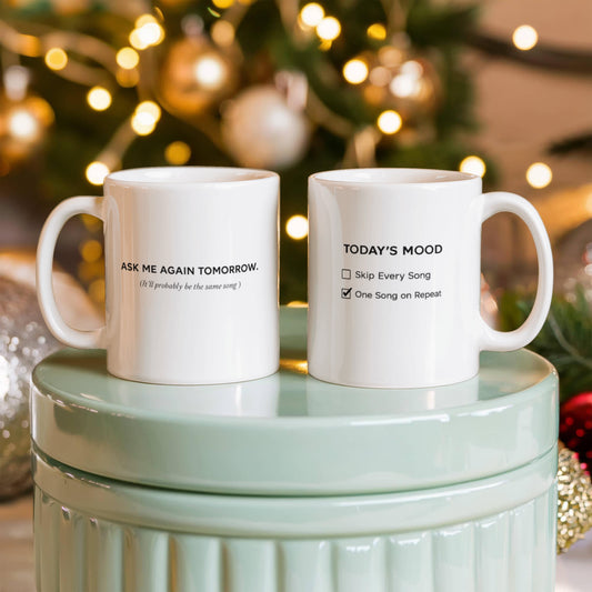 Reverse side of a white mug reading “Ask Me Again Tomorrow. It’ll Probably Be the Same Song.”
